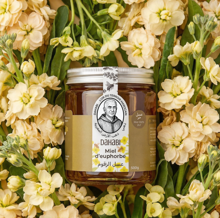 Pot de miel d'euphorbe Dahabi sur des fleurs jaunes