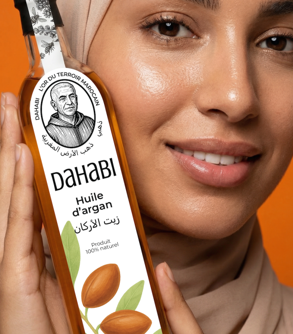 Une femme tient une bouteille de huile d'argan